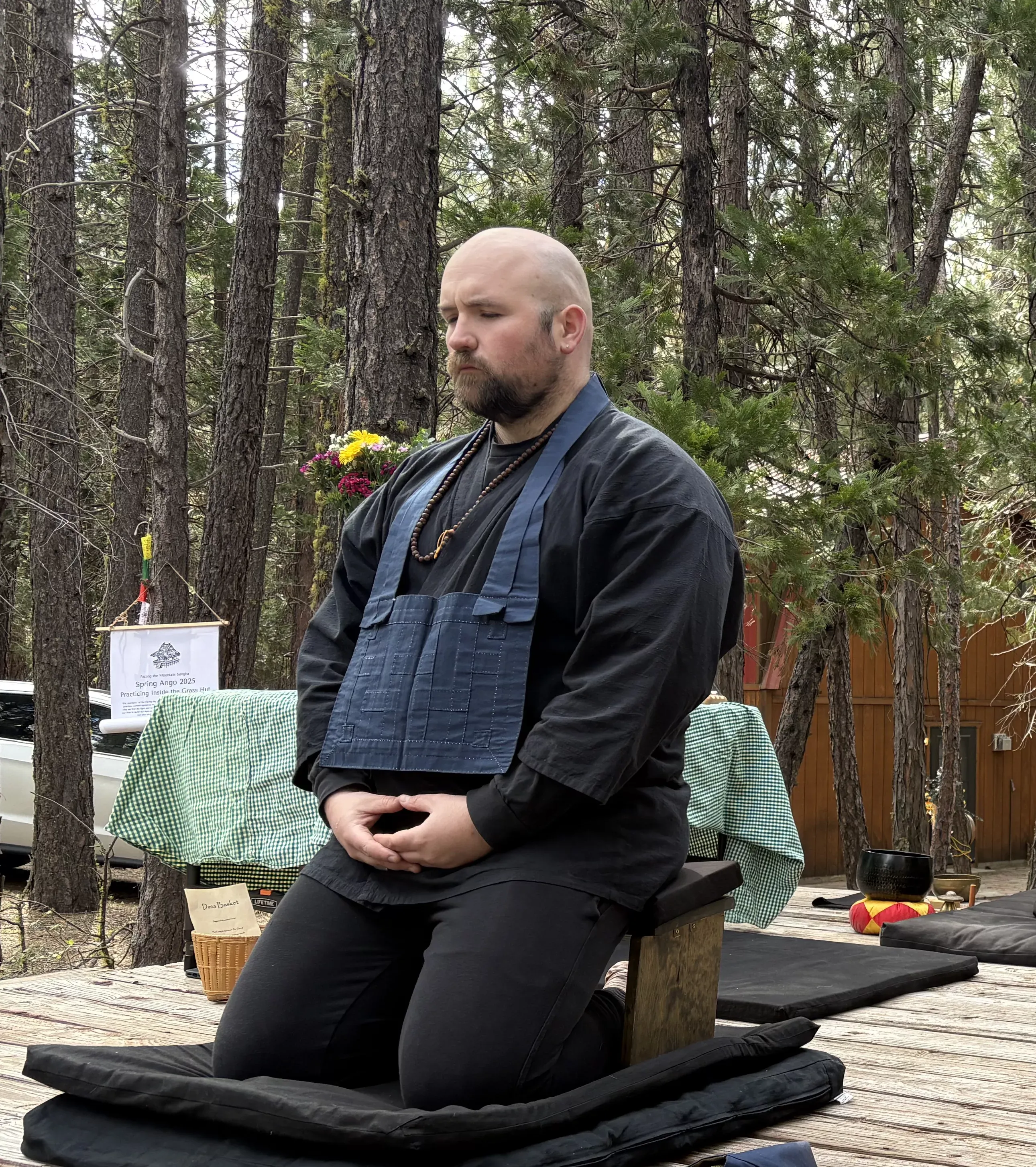 Noel sitting on a platform in the forest.