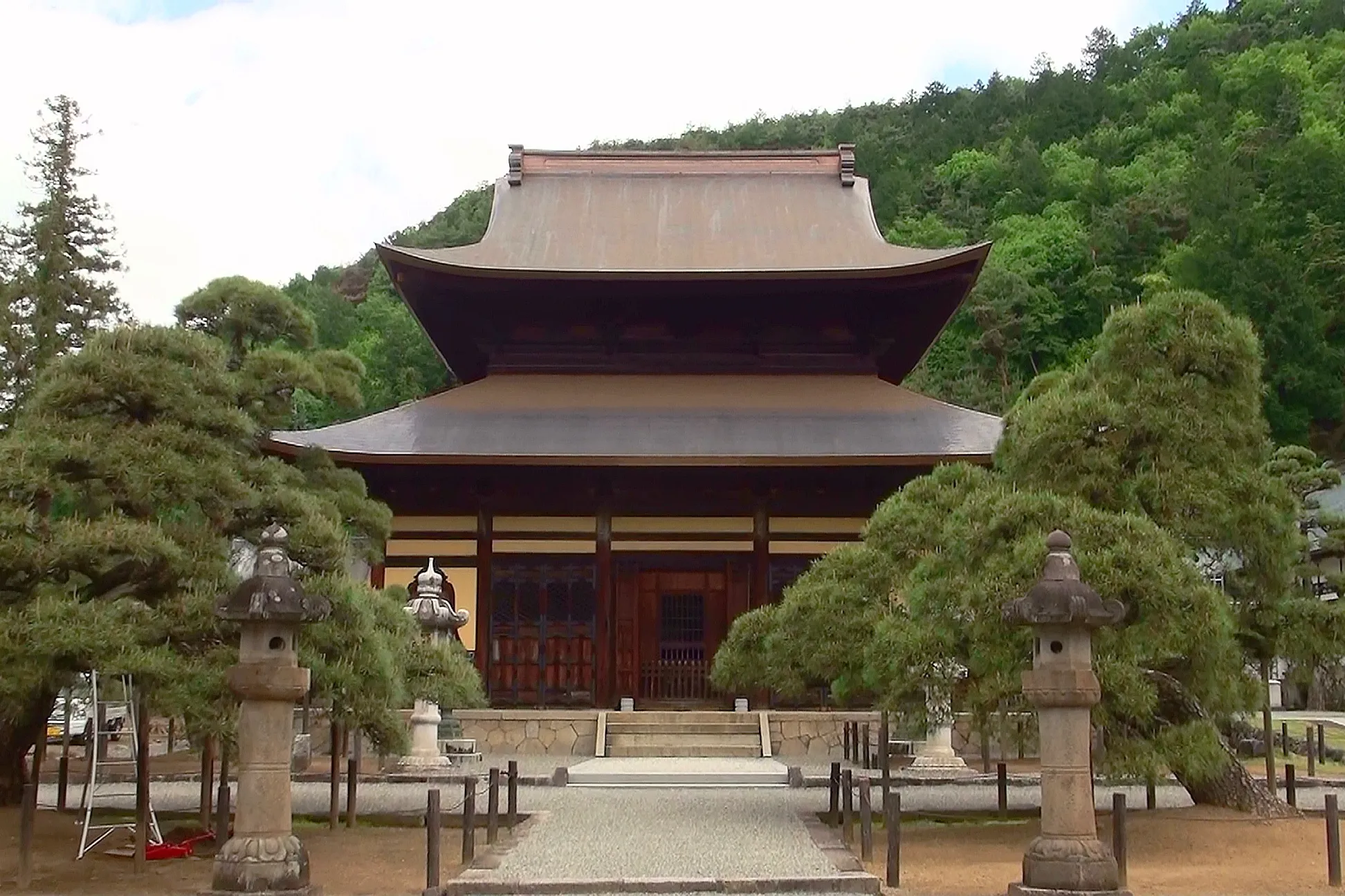 Photo of Kogakuji Temple in Japan, with a traditional wooden building and stone lanterns.