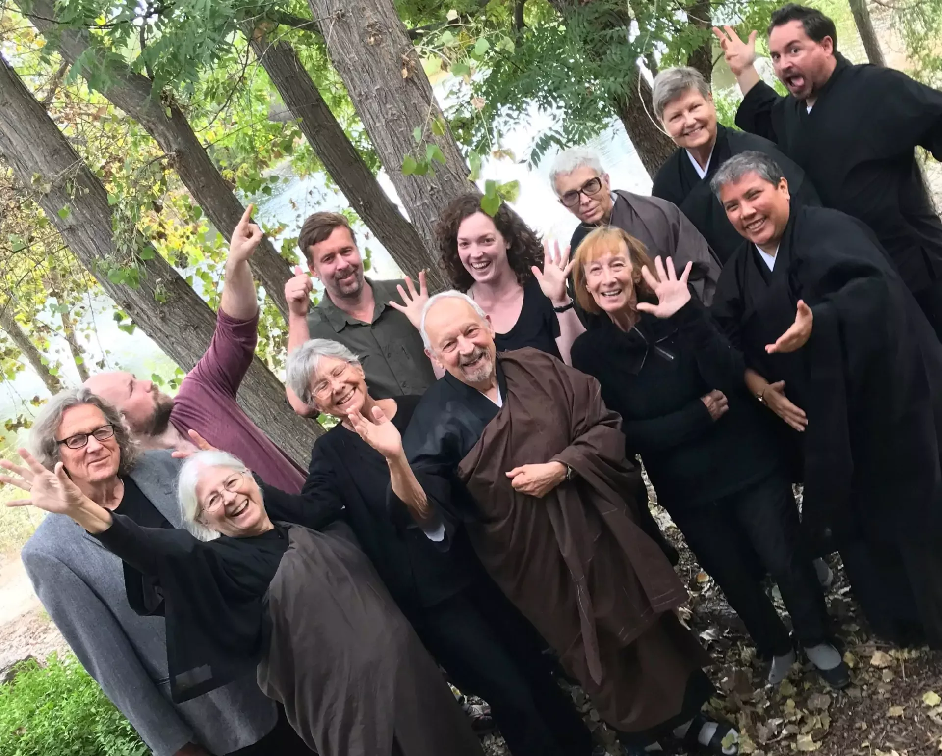 Members of the mountain sanghas in a group photo making a silly pose.