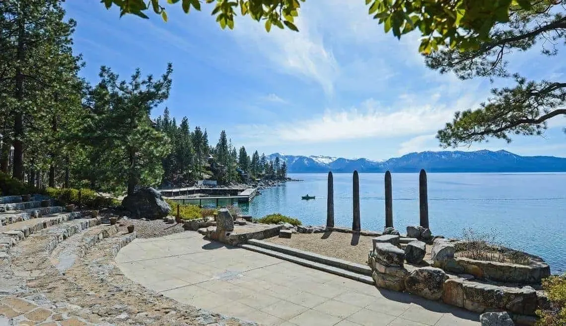 A photo of a rock amphitheater at Zephyr Point in Lake Tahoe, Nevada with the lake and a pier in the background.